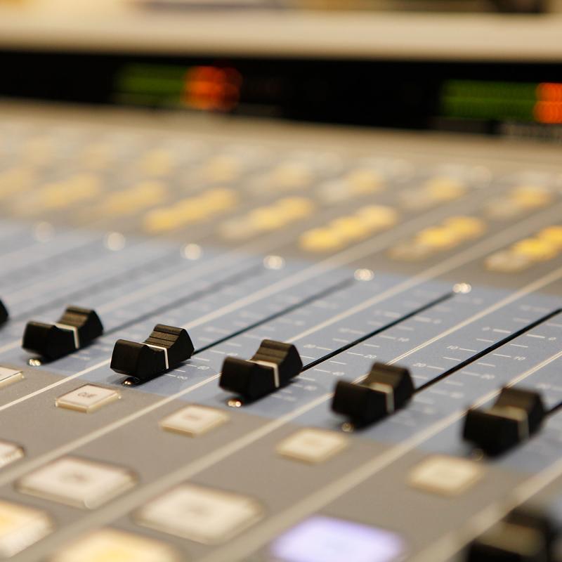 Close-up view of a music studio mixing board